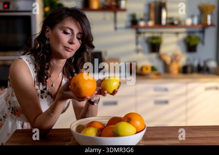 Femme avec des cheveux bouclés dans une tenue florale profitant de la lumière du soleil du matin, femme joyeuse avec des cheveux bouclés et robe florale capture les moments joyeux du matin près Banque D'Images