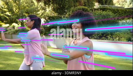 Pratiquant femme au premier plan avec les cheveux bouclés faisant du tai chi lent dans le jardin, des sommets roses, des stries de néon Banque D'Images