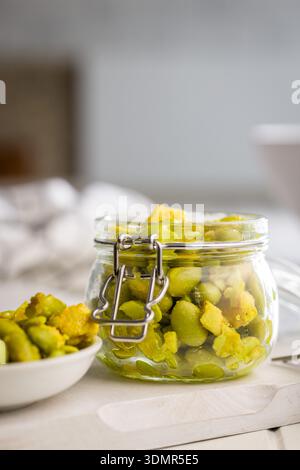 Salade fraîche avec des haricots edamame en pot sur une table blanche. Banque D'Images