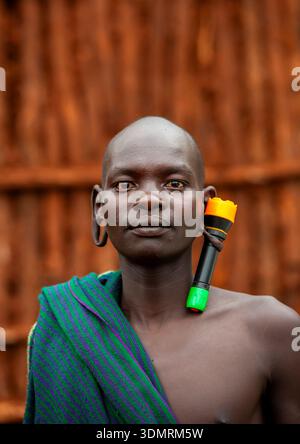 Homme de tribu Suri avec une oreille élargie décorée d'une lampe, Kibish, vallée de l'Omo, Ethiopie Banque D'Images