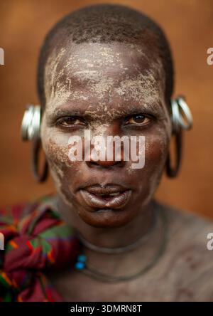Femme de la tribu Suri avec un lobe de l'oreille élargi et le visage peint, Kibish, vallée de l'Omo, Ethiopie Banque D'Images