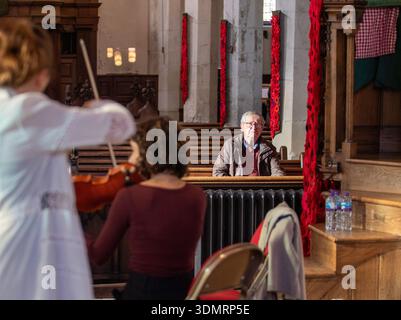 Assis un des premiers membres du public pendant que le Woolf String Quartet s'échauffe avant de donner un très excellent récital à St Michael's Church Framlingham Banque D'Images
