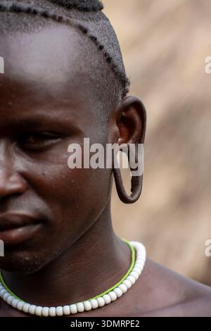 Portrait d'un homme de la tribu surma à l'oreille élargie, vallée de l'Omo, Tulgit, Ethiopie Banque D'Images