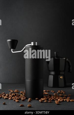 Kit de préparation manuelle du café avec cafetière à moka, moulin à main et haricots torréfiés. Concept de rituel de café premium avec éclairage dramatique, minimalisme, artisanat Banque D'Images