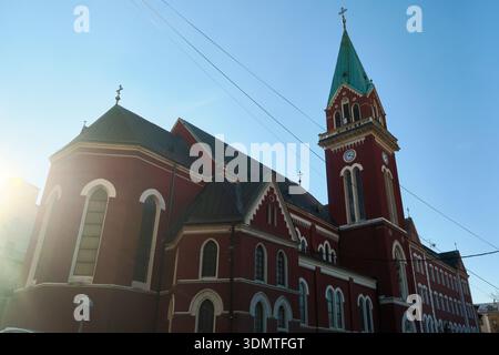 Église en briques rouges avec un grand clocher dans la ville européenne Banque D'Images