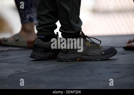 BANGKOK, THAÏLANDE-19 janvier 2026 : touriste féminine en chaussures de randonnée debout sur un sol en pierre, détail de texture de surface de vêtement, vue en angle élevé Banque D'Images