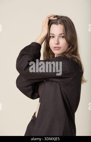 Jeune femme posant les mains sur la tête regardant la caméra Banque D'Images