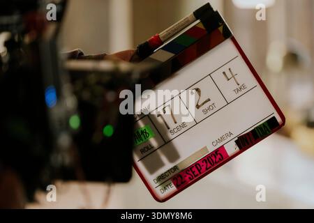 Gros plan d'une planche à clous utilisée lors d'une production cinématographique, tenue par un membre de l'équipe sur le plateau. Le tableau détaille la scène, prend des photos et prend des numéros, avec un appareil photo Banque D'Images
