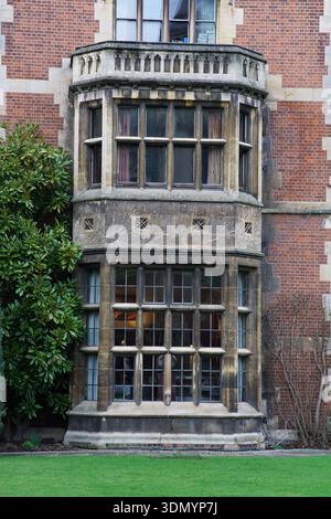 Élégante baie vitrée oriel sur le bâtiment historique de l'université de Cambridge en brique rouge surplombant la pelouse bien entretenue. Cambridge, Angleterre Banque D'Images