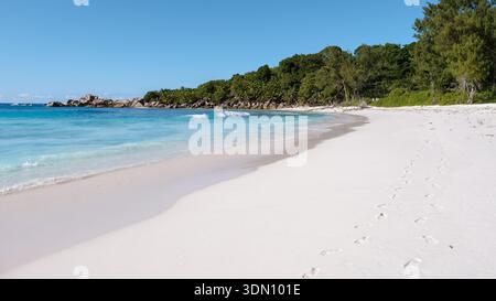 Le sable blanc doux et les eaux cristallines invitent les visiteurs à découvrir le paradis tranquille de la plage d'Anse Cocos. Une végétation luxuriante encadre le rivage, Banque D'Images