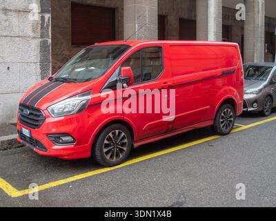 Cremona, Italie 6 février 2026 Red Ford transit Custom Sport van à panneaux avec des bandes de course noires élégantes, utilisées pour livrer des marchandises dans un buste Banque D'Images