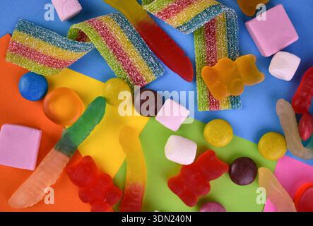 Beaucoup de bonbons sur un fond plat multicolore. Fond de bonbons. Banque D'Images