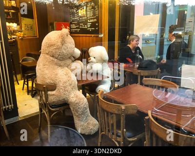 France, Paris, ours en peluche assis à table dans un café. Banque D'Images
