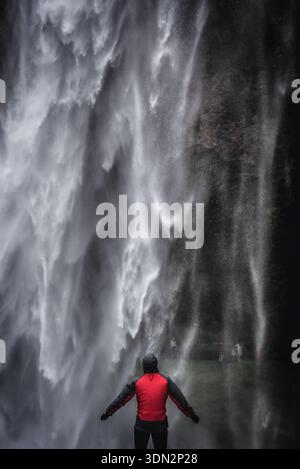 Région du Sud, Islande - 9 juin 2018 : touriste en face de la cascade Seljalandsfoss sur la rivière Seljalands qui a son origine dans le volcan Eyjafjallajokull Banque D'Images