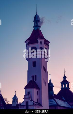 Prise de vue spectaculaire en bas angle de l'emblématique Lighthouse Tower à Sopot, en Pologne, silhouette sur un ciel dégradé passant du bleu profond au rose pâle. Banque D'Images