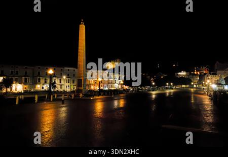Le monument cénotaphe illuminé la nuit sur la promenade avec des hôtels éclairés en arrière-plan, Llandudno, pays de Galles du Nord. Banque D'Images