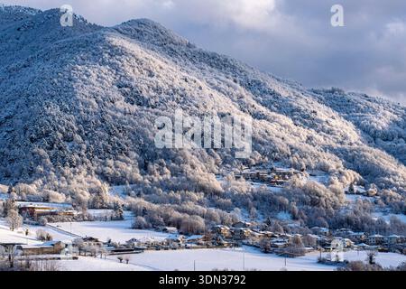 Village alpin enneigé au pied d'une montagne pendant la saison hivernale Banque D'Images