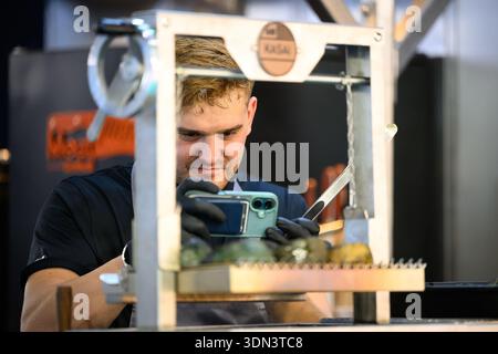 Un chef pâtissier professionnel photographiant ses créations gastronomiques à Host Milano 2025. Focus sur la photographie alimentaire et le marketing numérique dans le HoReCa indu Banque D'Images