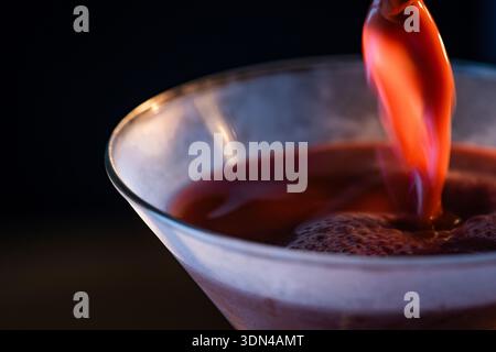 Gros plan d'un martini au chocolat versé dans un verre réfrigéré avec un fond de humeur changeante. Banque D'Images