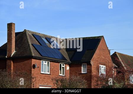 Toit de maison en briques rouges avec plusieurs panneaux solaires résidentiels au Royaume-Uni Banque D'Images
