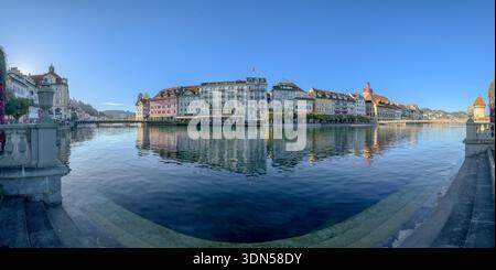 La rivière Reuss coule au cœur de Lucerne, en Suisse, avec des bâtiments historiques colorés bordant ses rives et se reflétant dans l'eau calme Banque D'Images
