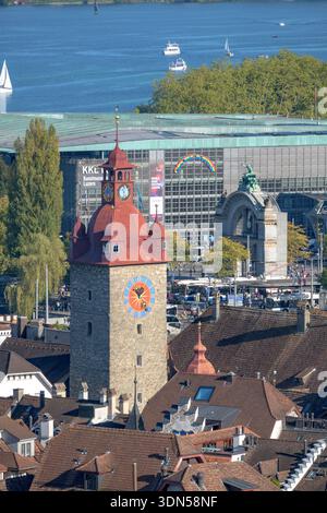 Une vue aérienne détaillée présente la tour de l'horloge emblématique de Lucerne, en Suisse, avec le lac serein et la vie urbaine animée en contrebas Banque D'Images