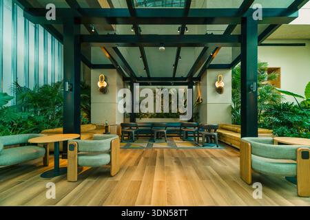 Design intérieur élégant d'un hall d'hôtel ou d'un salon de bureau avec fauteuils confortables en velours vert et tables dorées à Hollywood, Floride. Banque D'Images