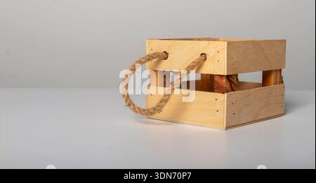 Petite caisse en bois avec des poignées de corde épaisses sur la table, fond de bannière. Banque D'Images