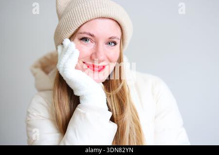 Portrait de style de vie ludique de femme en veste blanche souriant et posant à l'intérieur Banque D'Images