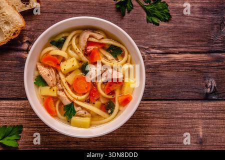 Soupe au poulet avec nouilles et légumes dans un bol blanc Banque D'Images