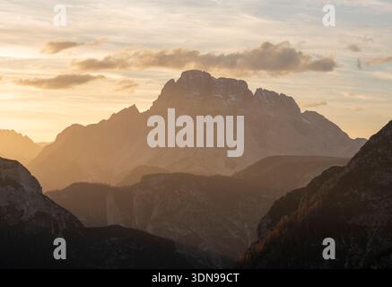 Coucher de soleil avec des tons de couleur dorée dans le ciel dans les régions alpines des Dolomites près de la Tre Cime di Lavaredo. Banque D'Images