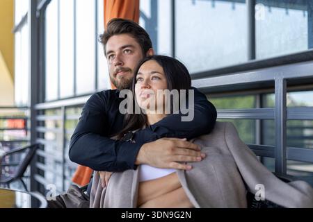 Jeune couple embrassant chaleureusement sur une terrasse en plein air Banque D'Images