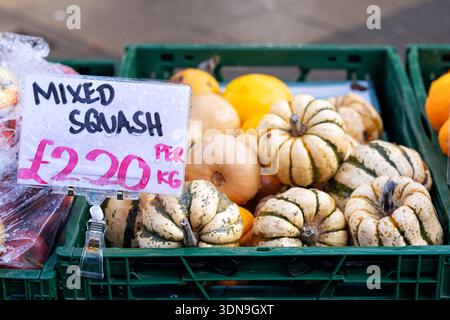 Bristol, Royaume-Uni. Un panier de présentation contenant des courges fraîches mélangées à l'extérieur d'un magasin Greengrocers. Les fruits sont tarifés et peuvent être sélectionnés par le client Banque D'Images