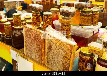 Juste, supermarché miel. Apiculteurs, différents types de miel dans des bocaux en verre et d'autres plats divers, y compris les nids d'abeilles et le miel avec des noix et mignon Banque D'Images