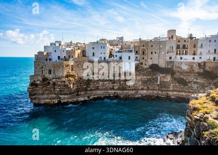 Vue imprenable sur les bâtiments côtiers blancs perchés sur des falaises accidentées au-dessus de la mer turquoise dans la ville de Polignano al Mare, Pouilles, Italie Banque D'Images