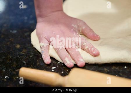 Mains étalant la croûte de pizza Banque D'Images
