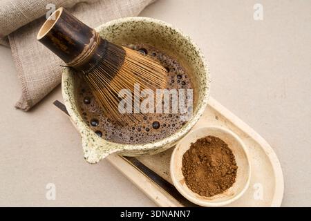 Préparer du thé vert matcha avec un fouet traditionnel en bambou, de l'eau chaude et du thé en poudre Banque D'Images