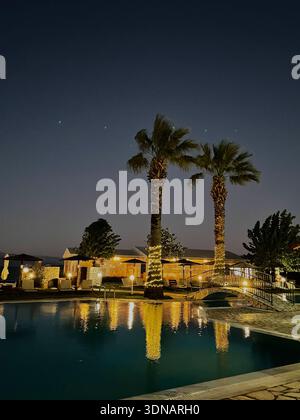 Piscine luxueuse de l'hôtel la nuit avec palmiers illuminés Banque D'Images