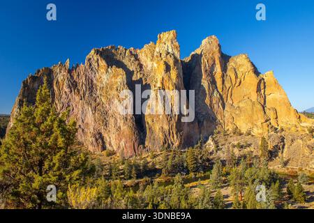Les falaises spectaculaires et abruptes de Smith Rock dominent le paysage désertique sous un ciel d'été clair et bleu vif Banque D'Images