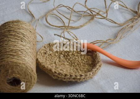 Processus de crochet panier de jute, élément de décoration intérieure. La fibre de jute naturelle est un matériau écologique. Gros plan. Copier l'espace Banque D'Images