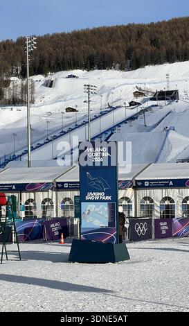 Livigno, Italie - 8 février 2026 : Milano Cortina 2026 Snow Park signe avec la marque olympique près des sauts à ski et des pistes enneigées à Livigno, Italie Banque D'Images