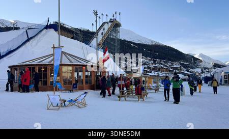 Livigno, Italie - 8 février 2026 : Milan Cortina 2026 saut à ski olympique Livigno avec tente drapeau autrichien, magasin officiel, foule diversifiée dans la neige Banque D'Images