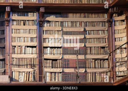 Une collection de livres vintage sur des étagères en bois dans une ancienne bibliothèque. Banque D'Images