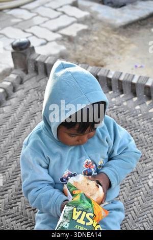 Une vue enfant porter un sweat à capuche et un siège sur le lit Banque D'Images