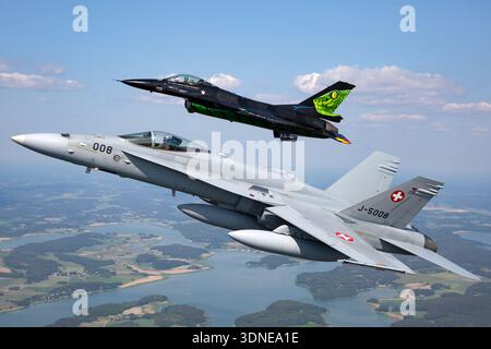 F-16AM belge « Dream Viper », Reg. FA-87 et Swiss F/A-18C Hornets, Reg. J-5008, effectue des vols de formation acrobatique au Turku Airshow 2023 en Finlande. Les avions ont une conception d'aile basse, une canopée à bulles, une capacité multirôle, une livrée personnalisée, un art de queue, fuselage, gouvernes, bout d'aile et avionique avancée. Des démonstrations air-air mettent en valeur la maniabilité, les performances de vol et la démonstration publique d'avions de chasse multirôles. Banque D'Images