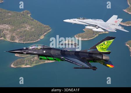 Le F-16AM belge FA-87, série 6H-87, et le F/A-18C Hornets suisse J-5008 et J-5016, séries 1336/SFC008 et 1363/SFC016, effectuent des acrobaties aériennes de formation au Turku Airshow 2023. F-16AM propulsé par des moteurs F100-PW-220 et F/A-18C par des moteurs F404-GE-402. Les perspectives air-air et les vues pilotes rapprochées mettent en valeur l'agilité, la précision et les capacités multirôles avec des peintures personnalisées et des dessins de queue pour l'affichage. Banque D'Images