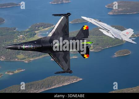 Le F-16AM FA-87, série 6H-87, Armée de l'Air belge, et le F/A-18C J-5008, série 1336/SFC008, volent en formation avec des manœuvres bancaires au Turku Airshow 2023. F-16AM propulsé par turboréacteur F100-PW-220 et F/A-18C par F404-GE-402. Les vues en gros plan du pilote et les prises de vue air-air montrent précision, agilité, capacité opérationnelle multirôle et affichage acrobatique avec peinture et queue personnalisées Banque D'Images