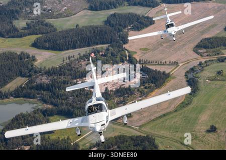 Dans une photographie de formation air-air au Turku Airshow Finland 2023, deux avions Ilmavoimat Grob G-115E Tutor de la Force aérienne finlandaise, reg GO-13 et GO-14, sont vus de près du point de vue d'un pilote. L'avion d'entraînement léger est équipé d'un moteur à pistons Lycoming AEIO-360-B1F avec deux sièges, un large auvent et un train tricycle fixe. Il est utilisé pour l'entraînement au vol élémentaire et la manipulation acrobatique de base. Banque D'Images