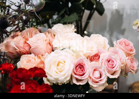Grand bouquet de roses rouges, roses et blanches se trouve dans le cadre du studio. Fleuriste de luxe marque, arrangement floral premium, cadeau d'entreprise Banque D'Images