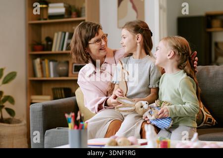 Femme d'âge moyen souriant tout en parlant avec deux filles Banque D'Images